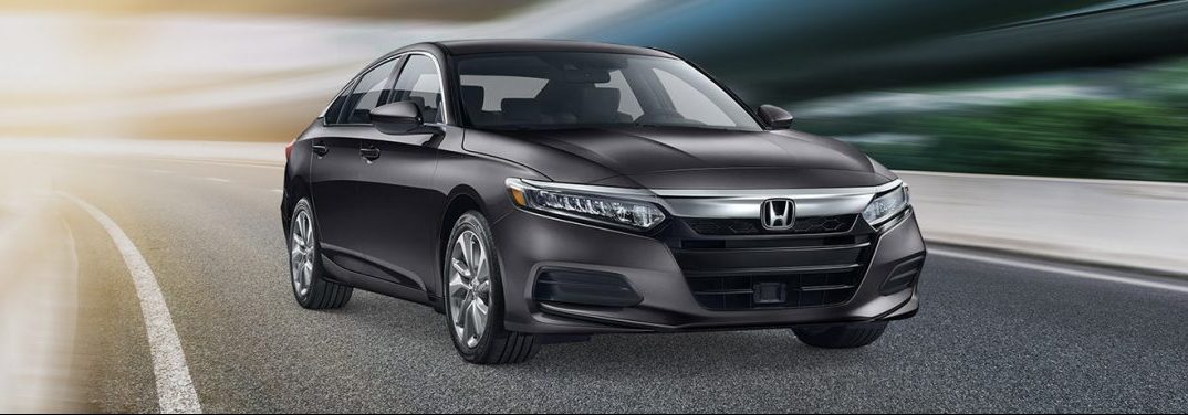 Black 2019 Honda Accord Sedan drives down a highway.
