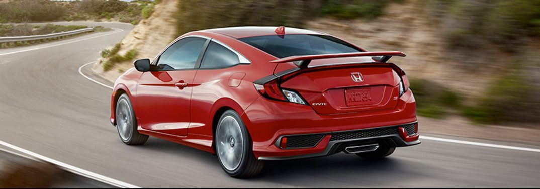 Red 2019 Honda Civic Coupe drives along a winding mountain highway.