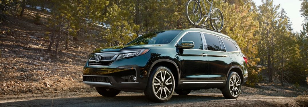 Green 2020 Honda Pilot with Bike on Roof on Country Road