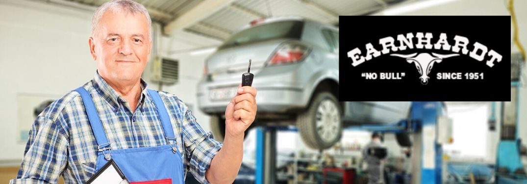 Mechanic in a Garage Holding a Key with Black and White Earnhardt Logo