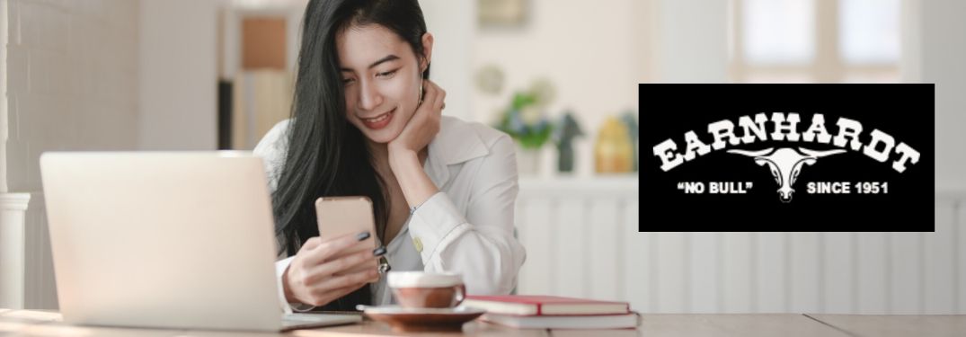 Woman on a Phone and Laptop with Black and White Earnhardt Logo