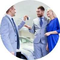 Car Salesman Handing Keys to a Happy Couple