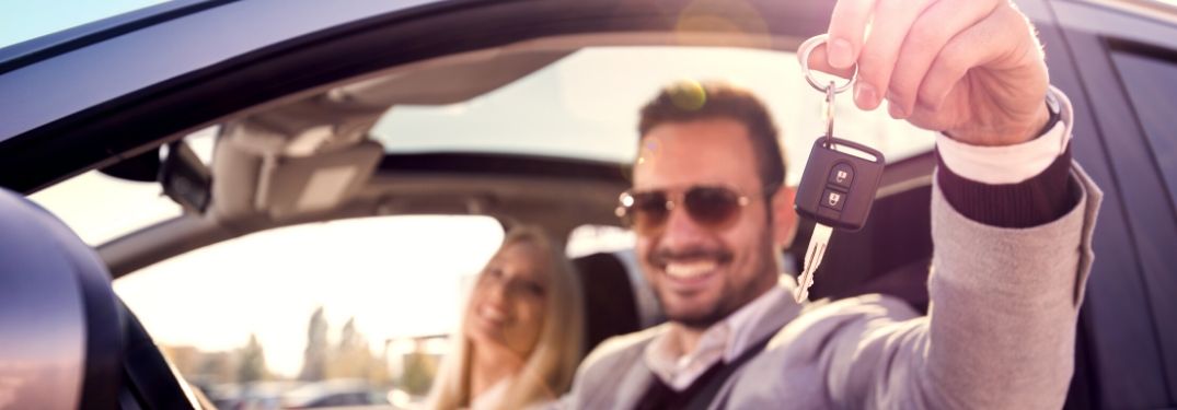 Young Couple in a Car Holding Up New Keys