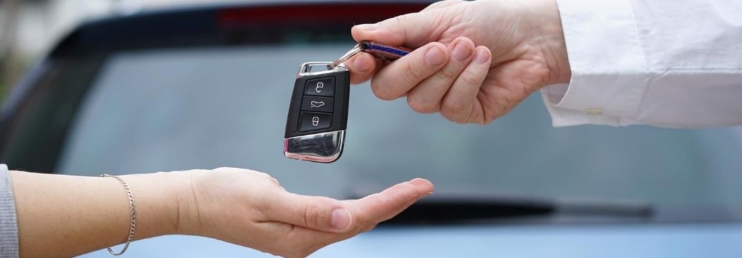Close Up of a Man Handing Keys to a Woman