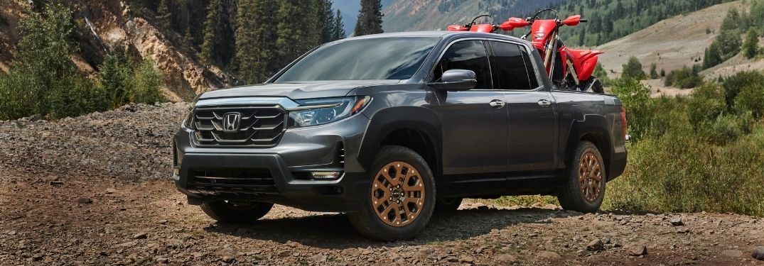Gray 2021 Honda Ridgeline with Dirt Bikes on a Trail