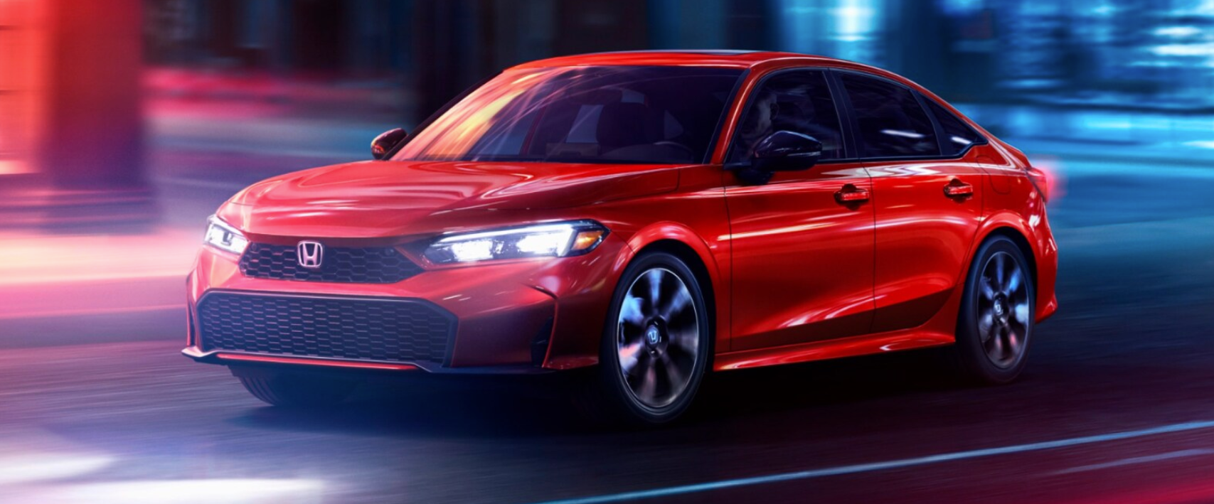 A bright red Honda Civic sedan drives on a street at night, with neon light trails in the blurred background.