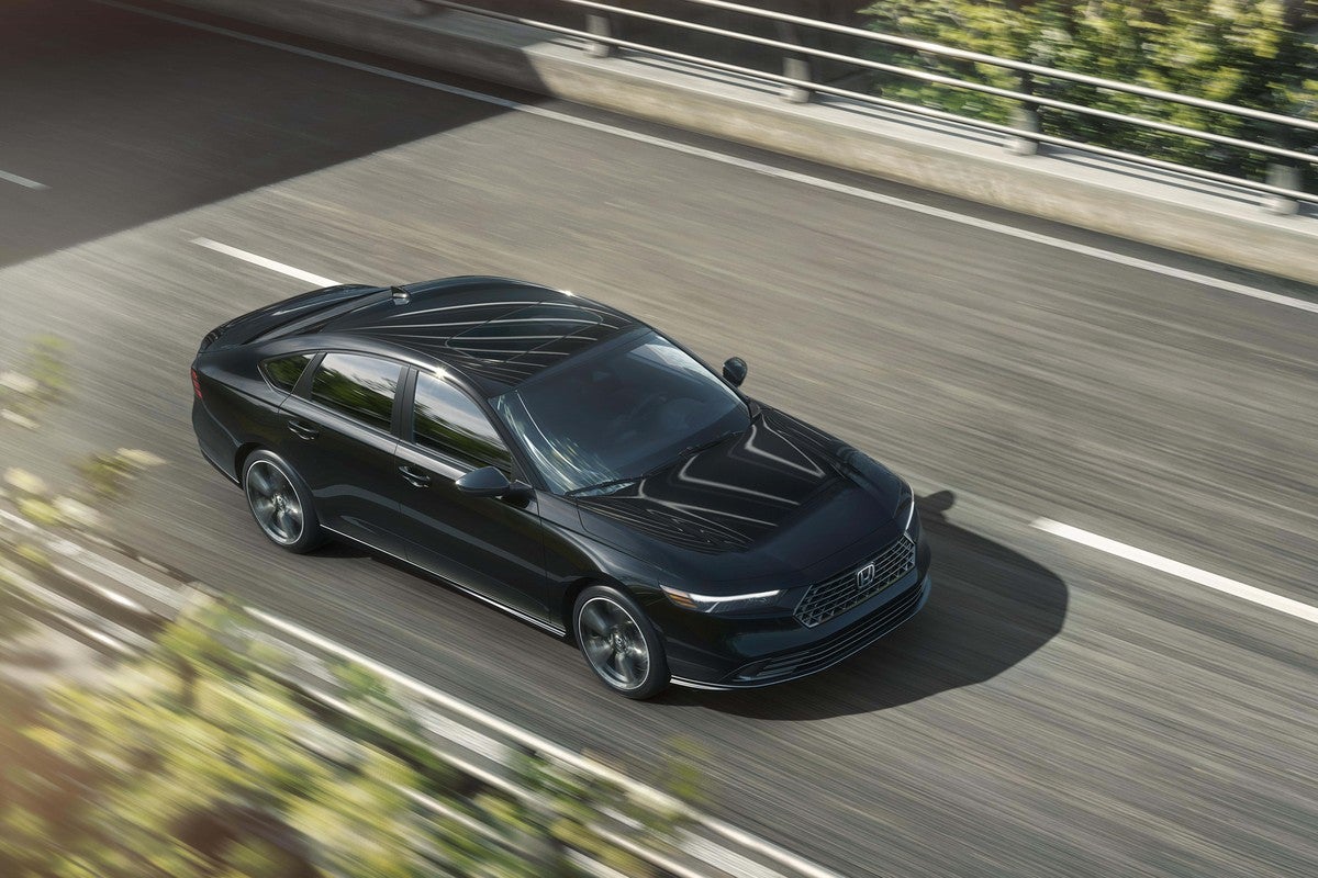A black new Accord in Phoenix drives towards the viewer to the right on a two-lane country road seen from a high angle.