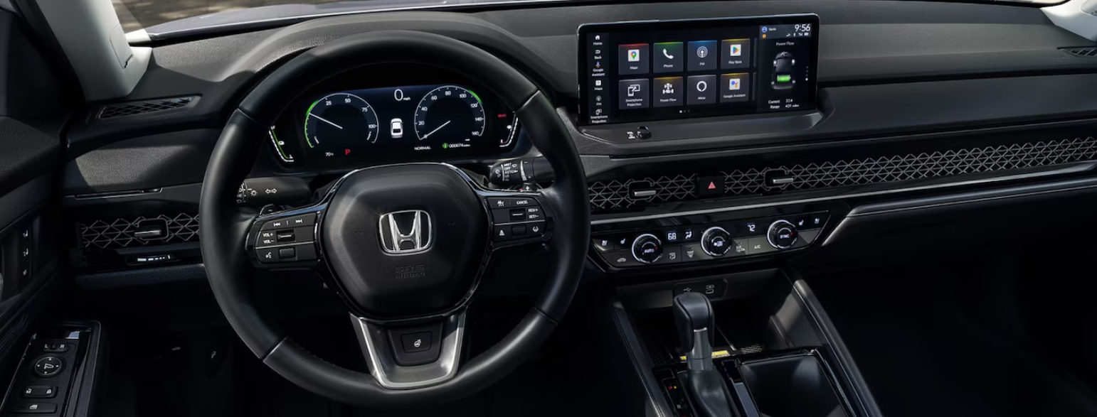 Interior view of a 2024 Honda Accord Hybrid Touring dashboard and steering wheel.